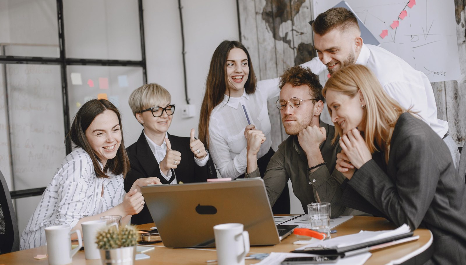 Business and technology team collaborating around a laptop in a modern office